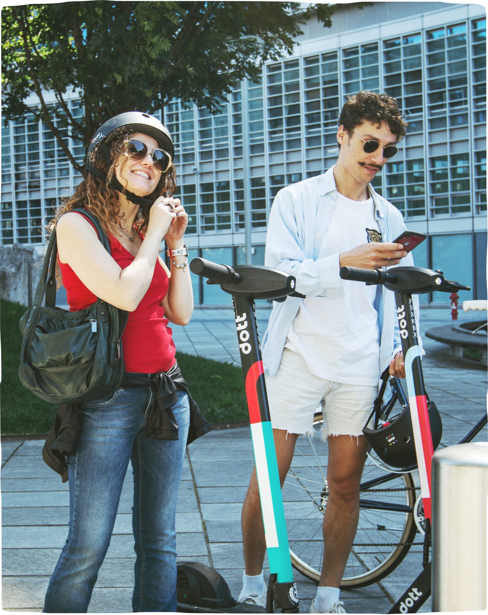 A man and woman rider in helmets and sunglasses, stopping to check their phone for tips on how to ride.